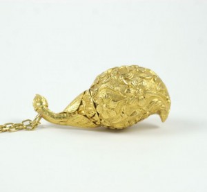 A gold necklace with a bird on it.