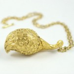 A gold necklace with a large object on it.