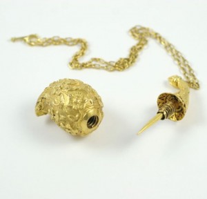 A gold necklace and earring set with a pineapple.
