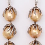 A pair of gold and diamond earrings with pearls.