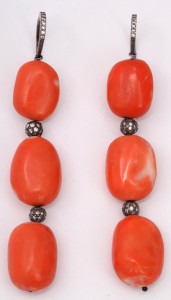 A close up of two necklaces with red beads