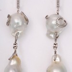 A pair of earrings with pearls and diamonds.