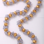 A long necklace of gold and blue beads.