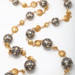 A long necklace with gold and black beads