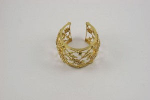 A gold bracelet with a design on it.