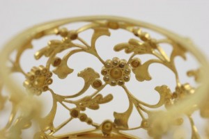 A close up of the gold filigree on the bottom of a bowl