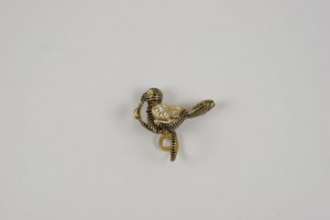 A gold colored metal object with a bird on it.