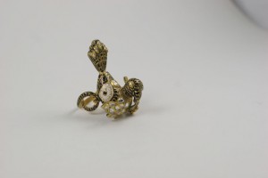 A gold bird with a chain around it's neck.