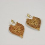 A pair of gold earrings with a heart shaped design.