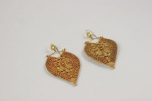 A pair of gold earrings with a heart shaped design.