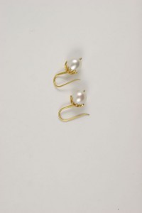 A pair of gold earrings with pearls on them.