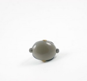 A gray and gold ring sitting on top of a white surface.