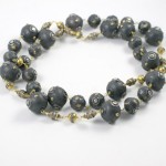 A long necklace of black and gold beads