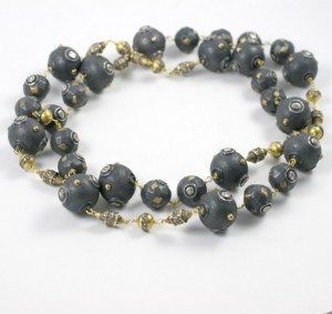 A long necklace of black and gold beads