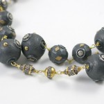 A close up of a necklace with black beads