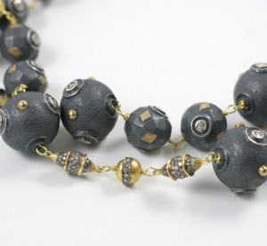 A close up of a necklace with black beads