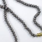 A long necklace with silver beads and gold bead.