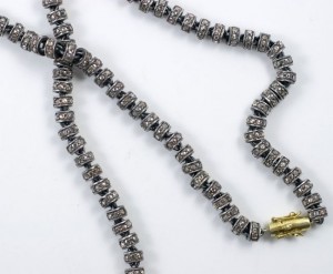 A long necklace with silver beads and gold bead.