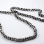 A close up of a necklace on a white surface