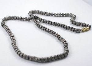 A close up of a necklace on a white surface
