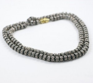A close up of a necklace on a white surface