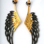 A pair of earrings with gold and black wings.