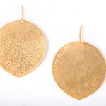 A pair of gold earrings with a leaf design.