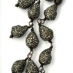 A close up of a necklace with silver beads