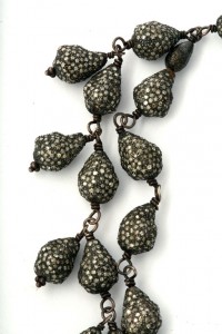 A close up of a necklace with silver beads