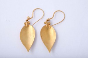A pair of gold earrings with a leaf design.