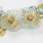 A close up of two earrings with gold flowers