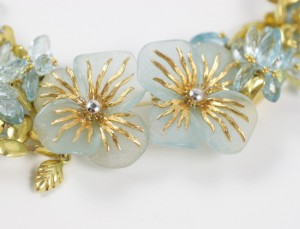 A close up of two earrings with gold flowers