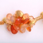 A close up of the necklace with orange stones