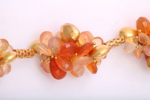 A close up of the necklace with orange stones