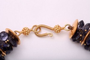 A close up of the gold chain and clasp on a necklace