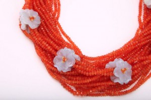 A close up of a necklace with orange beads