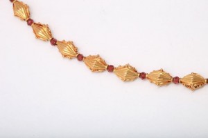 A gold chain with red stones on it.