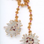 A necklace with two flowers and beads on it.