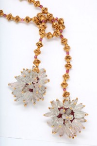 A necklace with two flowers and beads on it.