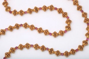 A close up of a necklace with pink beads