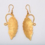 A pair of gold earrings with leaves on them.