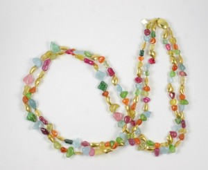 A long necklace of colorful beads and pearls.