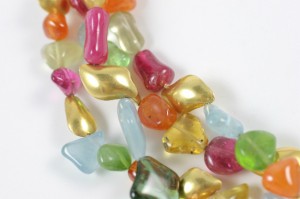 A close up of many different colored beads