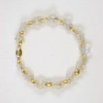 A gold and clear bracelet is shown on top of a white background.