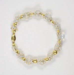 A gold and clear bracelet is shown on top of a white background.