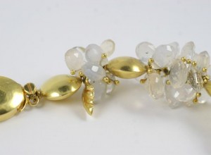 A pair of gold earrings with white stones.