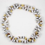 A necklace of white and gold beads is shown.