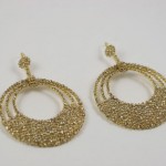 A pair of gold earrings with three circles.