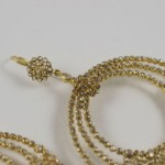 A close up of the gold chain on a white background