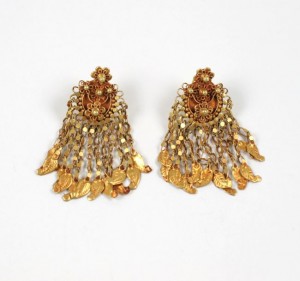 A pair of gold earrings with dangling beads.